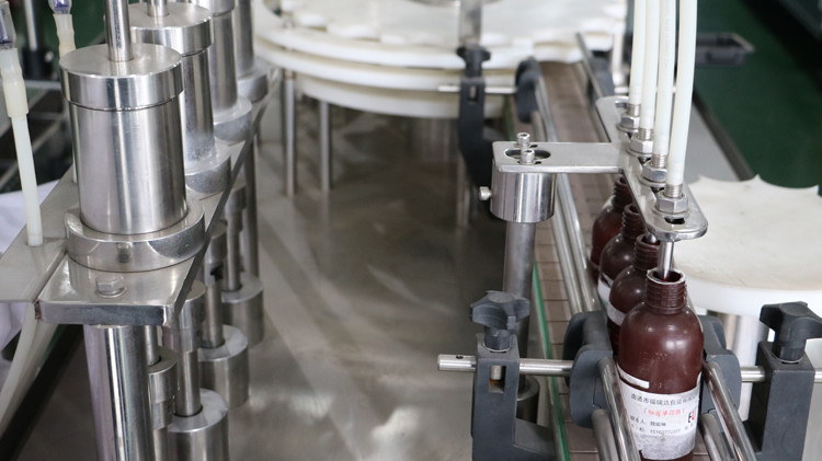 Machine de remplissage de bouteilles rondes de 500 ml avec étanchéité du bouchon et fonctionnement de la roue en étoile